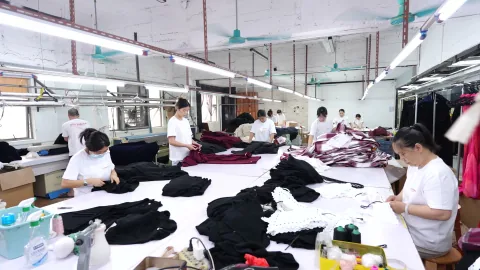 OTO team organises finished garments on a preparation table