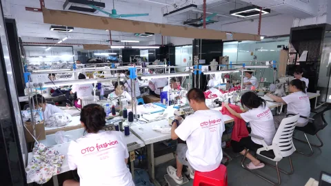 OTO production team sewing garments at workshop stations