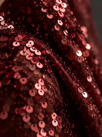 Close-up of overlapping burgundy sequins sewn onto fabric
